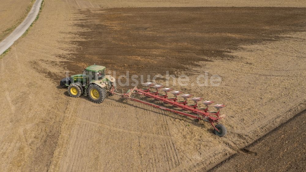 Luftbild Sauheim - Umpflugarbeiten und Umschichtung der Erde durch einen Traktor mit Pflug auf landwirtschaftlichen Feldern in Sauheim im Bundesland Bayern
