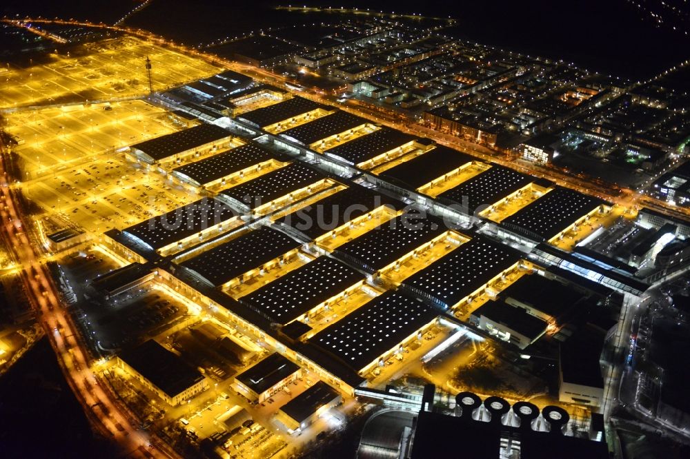 München bei Nacht aus der Vogelperspektive: Nachtluftbild der beleuchten Ausstellungshallen am Messegelände München im Bundesland Bayern