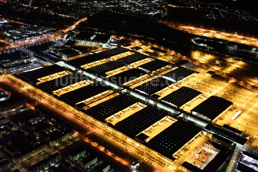 Nacht-Luftaufnahme München - Nachtluftbild der beleuchten Ausstellungshallen am Messegelände München im Bundesland Bayern