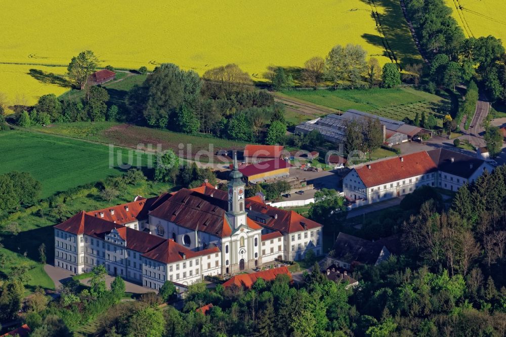 Schäftlarn aus der Vogelperspektive: Abendlich beleuchteter Gebäudekomplex des Klosters vor einem gelb blühenden Rapsfeld in Schäftlarn im Bundesland Bayern