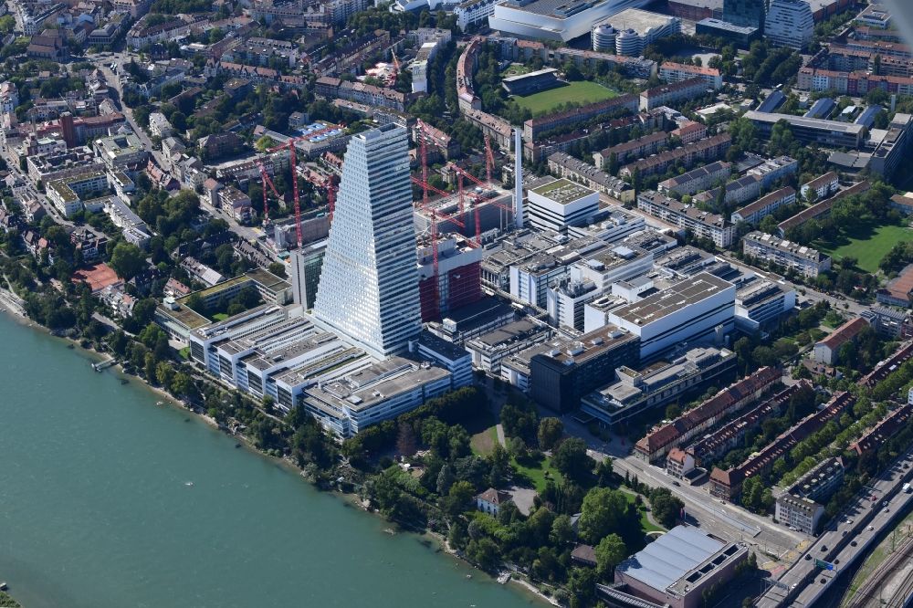 Luftaufnahme Basel - Areal und Betriebsgelände der Pharmafirma Roche mit dem stadtbildprägenden Hochhaus und der Baustelle für den zweiten Turm in Basel am Rhein in der Schweiz