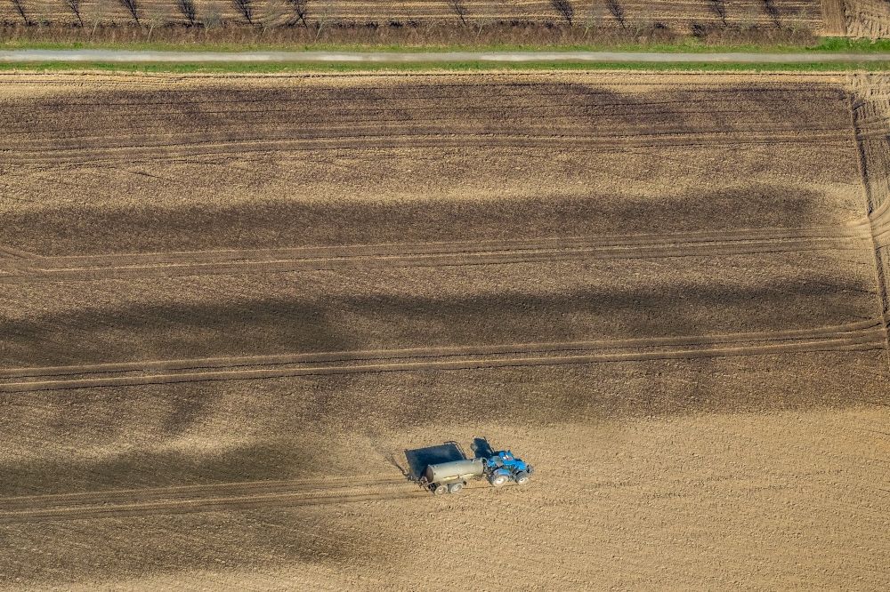 Luftbild Friedrichsfeld - Ausbringung von Gülle als Dünger mit Traktor und Tankanhänger auf landwirtschaftlichen Feldern in Friedrichsfeld im Bundesland Nordrhein-Westfalen, Deutschland