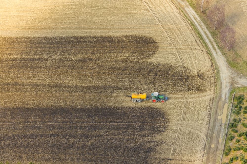 Luftaufnahme Enkdorf - Ausbringung von Gülle als Dünger mit Traktor und Tankanhänger auf landwirtschaftlichen Feldern in Enkdorf im Bundesland Nordrhein-Westfalen, Deutschland