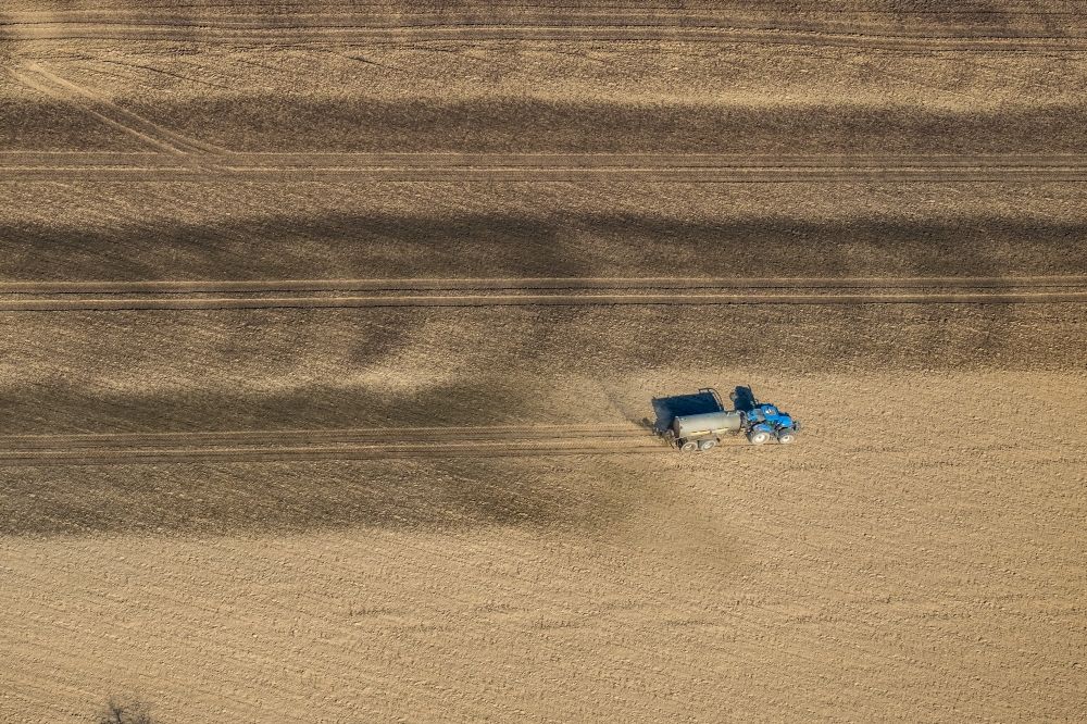Luftaufnahme Friedrichsfeld - Ausbringung von Gülle als Dünger mit Traktor und Tankanhänger auf landwirtschaftlichen Feldern in Friedrichsfeld im Bundesland Nordrhein-Westfalen, Deutschland