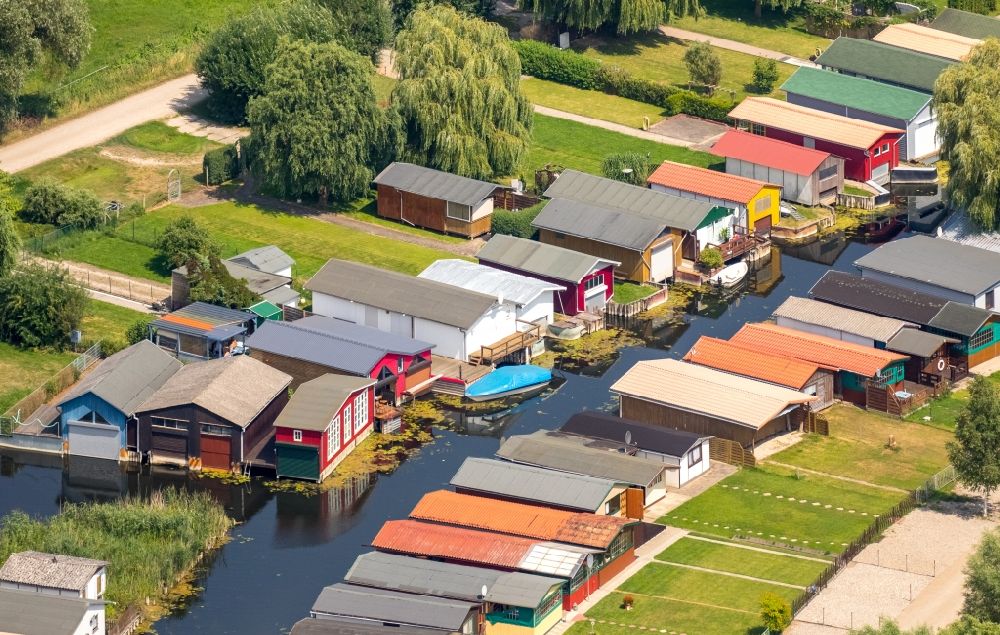 Luftaufnahme Neukalen - Bootshaus- Reihen mit Sportboot- Anlegestellen und Bootsliegeplätzen am Uferbereich der Peene in Neukalen im Bundesland Mecklenburg-Vorpommern