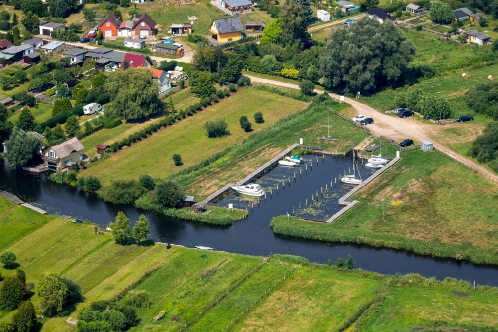 Neukalen von oben - Bootshäuser mit Sportboot- Anlegestellen und Bootsliegeplätzen am Uferbereich der Peene in Neukalen im Bundesland Mecklenburg-Vorpommern