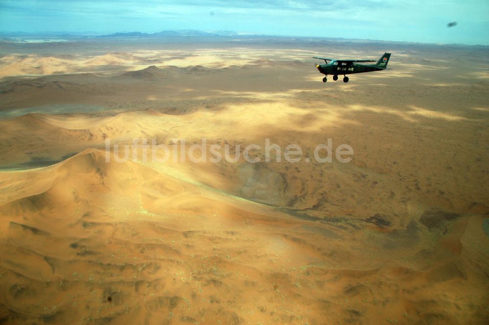 Windhoeck aus der Vogelperspektive: Cessna 182 im Formationsflug über der Wüste in Namibia - Cessna 182 bush plane
