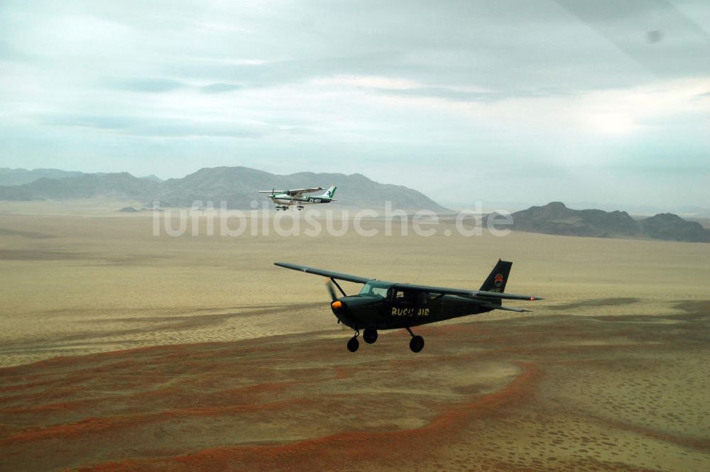 Luftbild Windhoeck - Cessna 182 im Formationsflug über der Wüste in Namibia - Cessna 182 bush plane