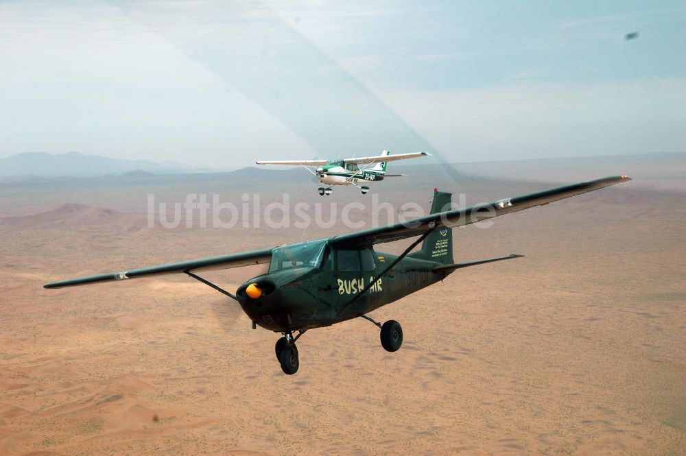 Windhoeck aus der Vogelperspektive: Cessna 182 im Formationsflug über der Wüste in Namibia - Cessna 182 bush plane