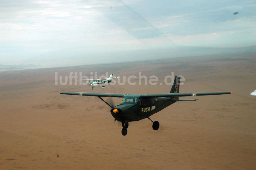 Luftbild Windhoeck - Cessna 182 im Formationsflug über der Wüste in Namibia - Cessna 182 bush plane