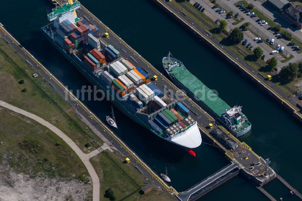 Luftaufnahme Kiel - Containerschiff in der Schleusenanlage Kiel-Holtenau Schleuseninsel am Nord-Ostsee-Kanal in Kiel im Bundesland Schleswig-Holstein