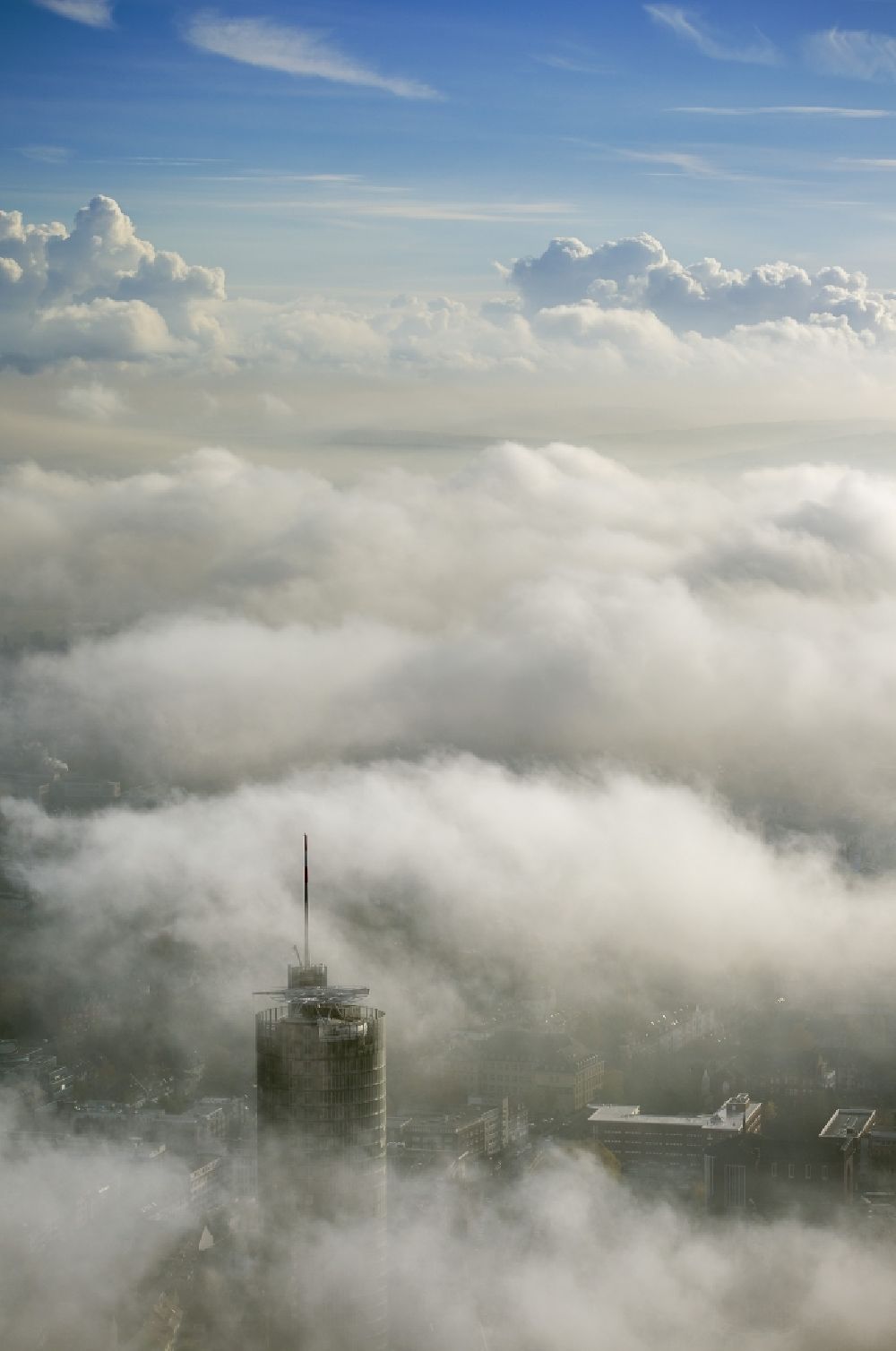 Luftbild Essen - Die Spitze des RWE- Turm Essen durchbricht eine imposante Nebel- und Wolkendecke über der Innenstadt im Bundesland Nordrhein-Westfalen
