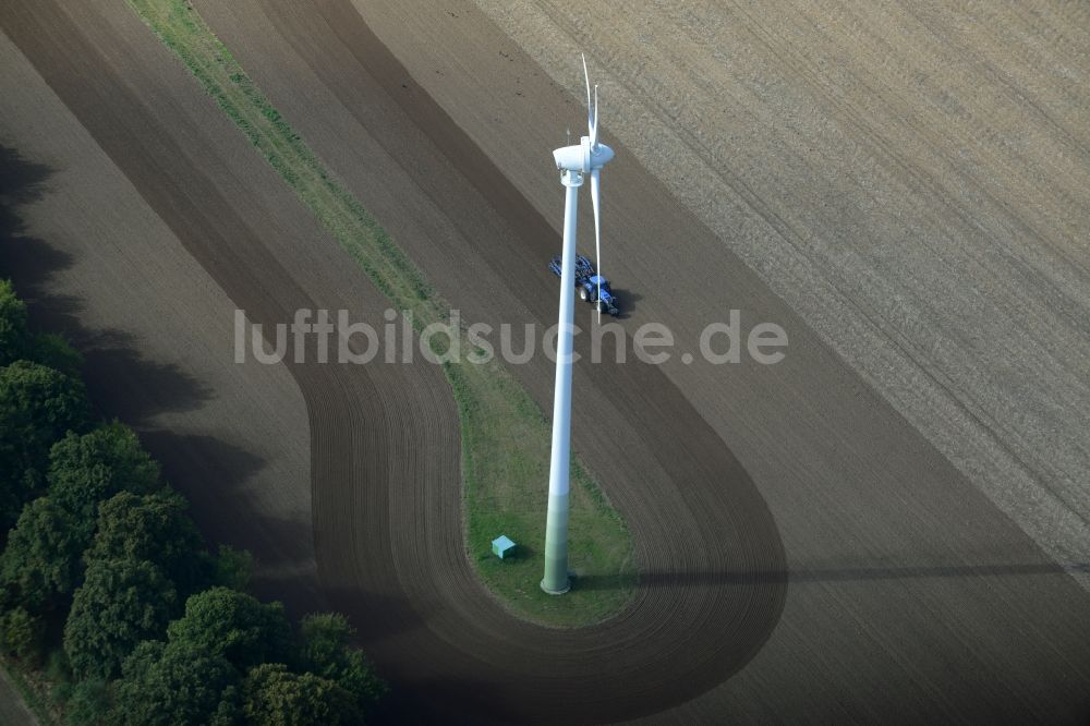 Luftaufnahme Kritzow - Ernte- Traktor umfährt Windenergieanlagen (WEA) - Windrad und Strukturen auf einem Feld in Kritzow im Bundesland Mecklenburg-Vorpommern