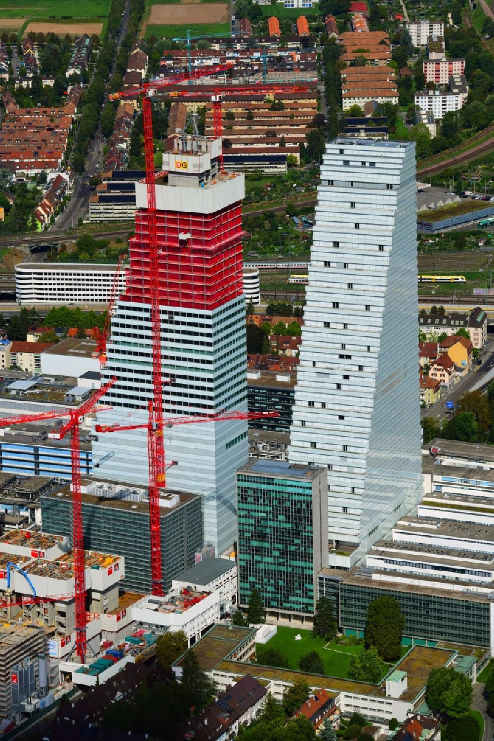 Luftaufnahme Basel - Erweiterungs- Baustellen und Baukräne am Areal und Betriebsgelände der Pharmafirma Roche mit dem Roche- Turm - Hochhaus in Basel in der Schweiz