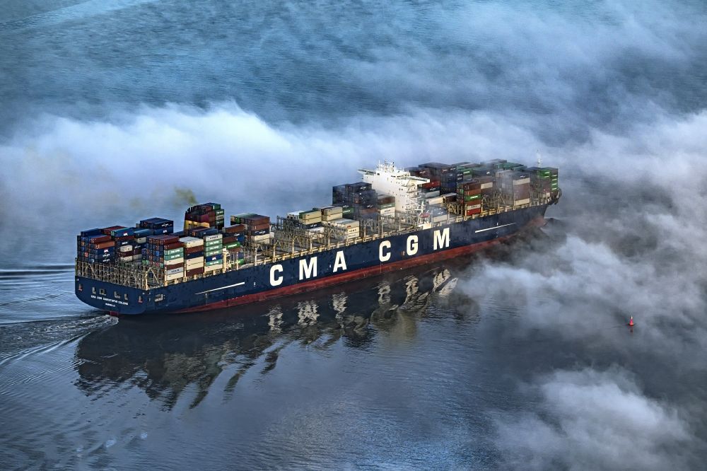 Hollern-Twielenfleth aus der Vogelperspektive: Fahrendes Containerschiff CMA CGM Christophe Columb auf der Elbe Höhe Hollern-Twielenfleth im Nebel in Niedersachsen, Deutschland
