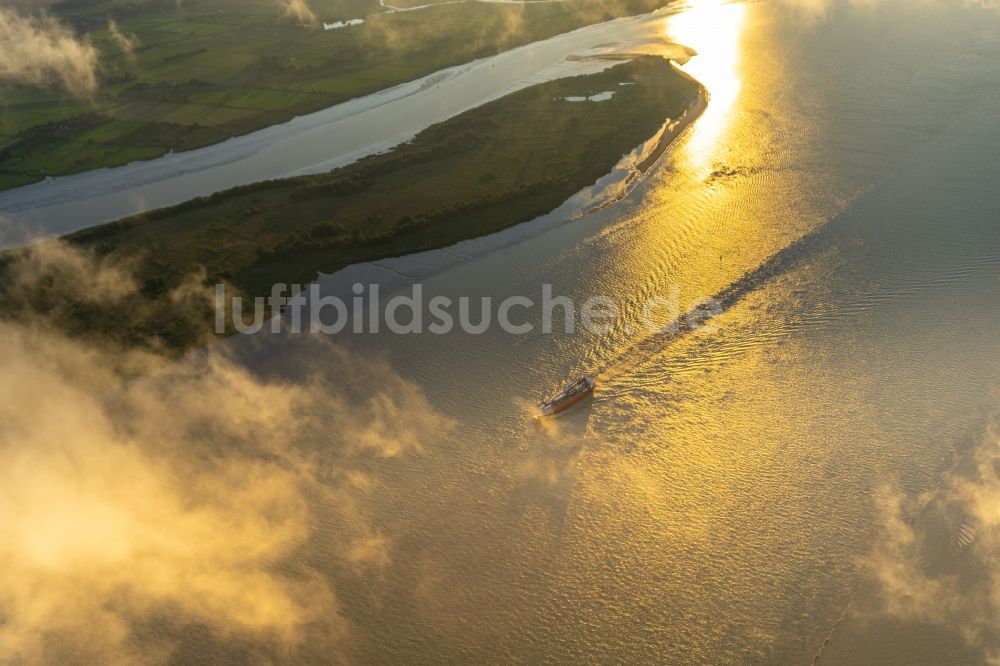 Luftbild Drochtersen - Fahrendes Containerschiff auf der Elbe im Sonnenuntergang in Drochtersen im Bundesland Niedersachsen, Deutschland