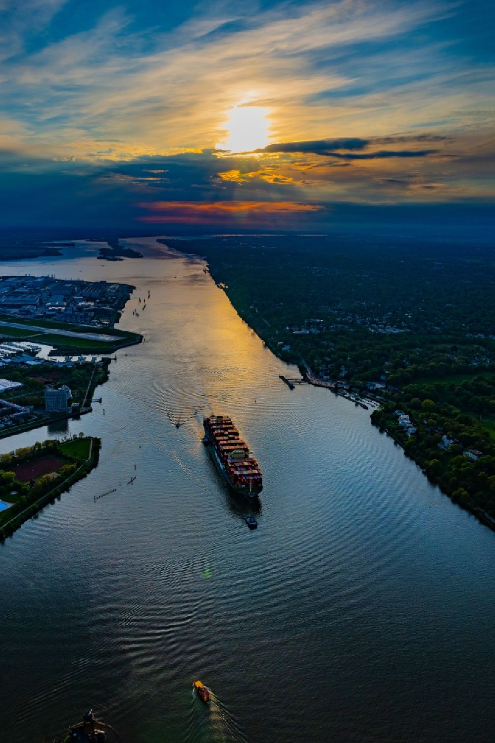 Luftaufnahme Hamburg - Fahrendes Containerschiff auf der Elbe im Sonnenuntergang in Hamburg, Deutschland