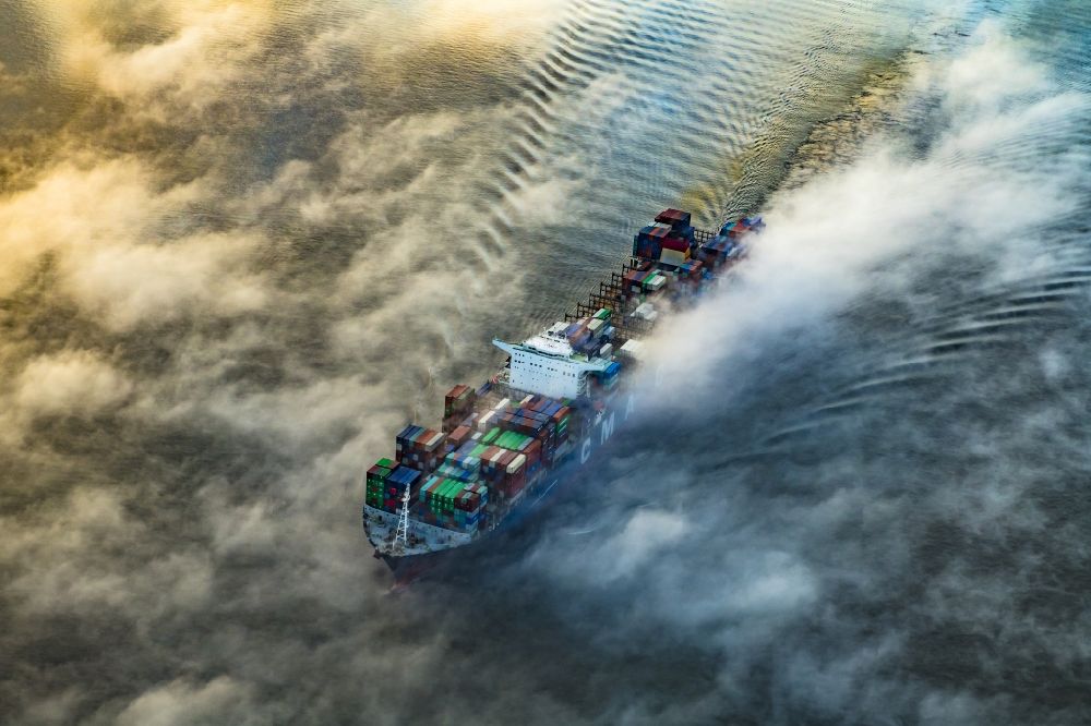Drochtersen von oben - Fahrendes Containerschiff in einer Nebelschicht auf dem Elbe- Flußverlauf in Drochtersen im Bundesland Niedersachsen, Deutschland