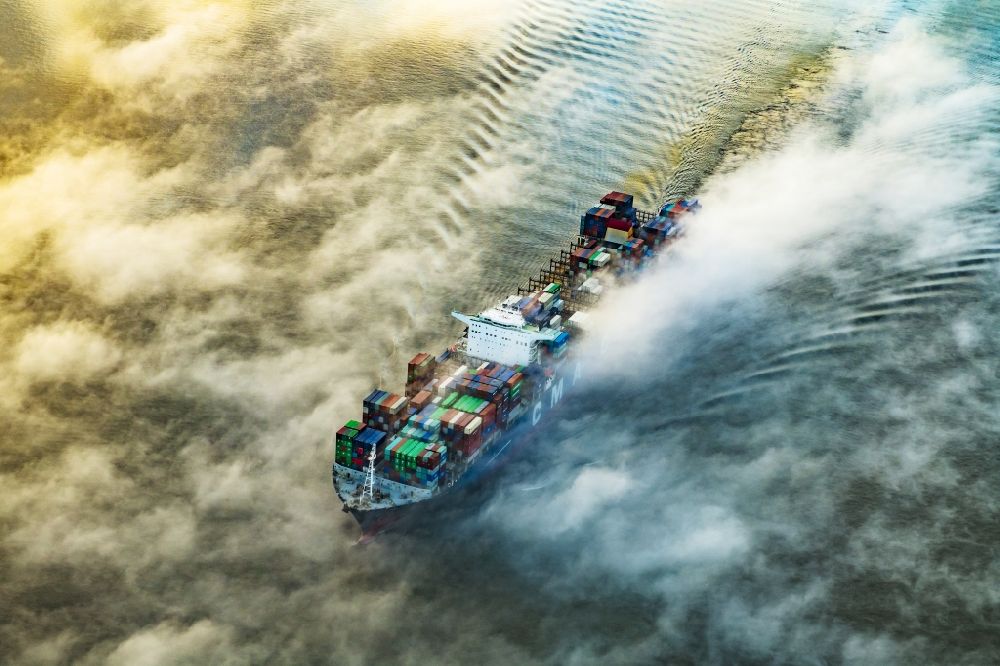 Drochtersen aus der Vogelperspektive: Fahrendes Containerschiff in einer Nebelschicht auf dem Elbe- Flußverlauf in Drochtersen im Bundesland Niedersachsen, Deutschland