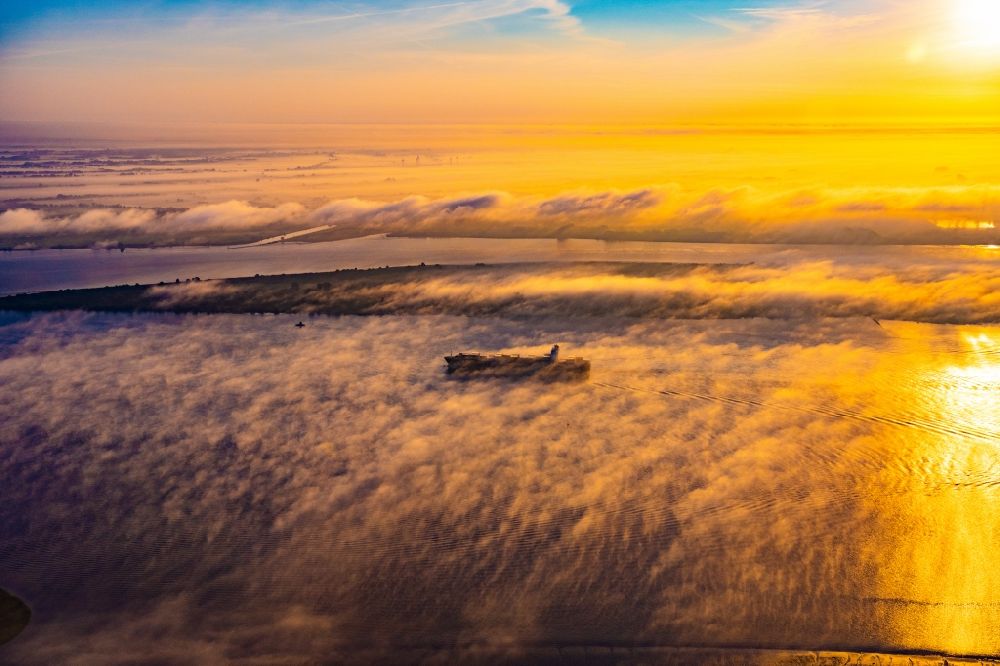 Kollmar aus der Vogelperspektive: Fahrendes Containerschiff in einer Nebelschicht auf dem Elbe- Flußverlauf in Kolmar im Bundesland Schleswig-Holstein, Deutschland