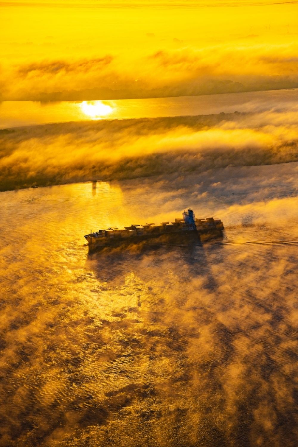 Luftbild Kollmar - Fahrendes Containerschiff in einer Nebelschicht auf dem Elbe- Flußverlauf in Kolmar im Bundesland Schleswig-Holstein, Deutschland