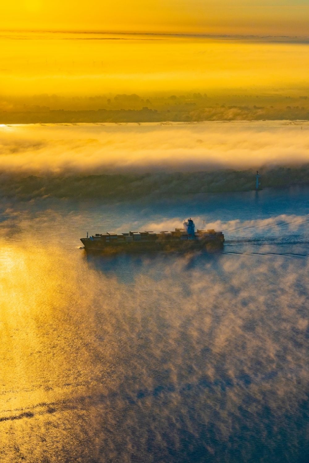 Luftaufnahme Kollmar - Fahrendes Containerschiff in einer Nebelschicht auf dem Elbe- Flußverlauf in Kolmar im Bundesland Schleswig-Holstein, Deutschland