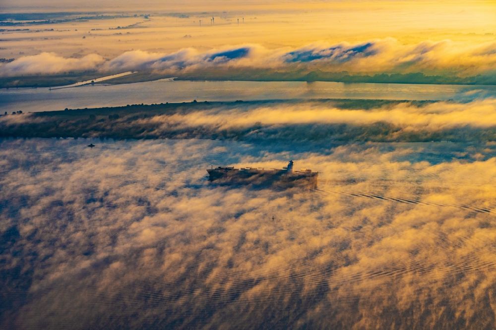 Kollmar aus der Vogelperspektive: Fahrendes Containerschiff in einer Nebelschicht auf dem Elbe- Flußverlauf in Kolmar im Bundesland Schleswig-Holstein, Deutschland