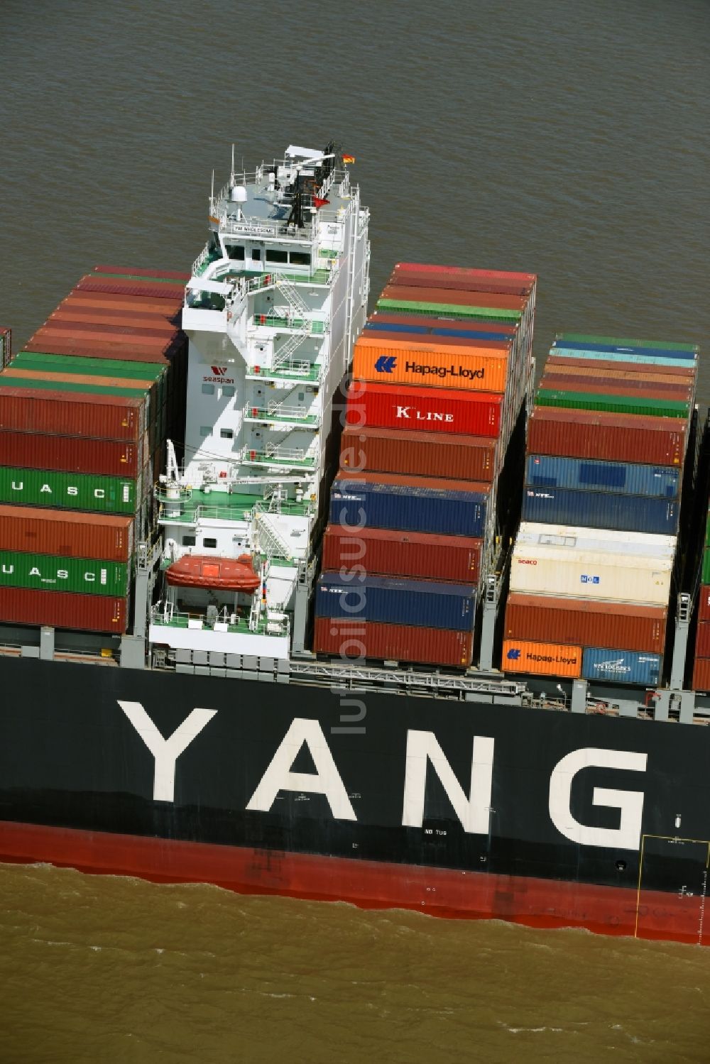 Luftaufnahme Bützfleth - Fahrendes Containerschiff YANG MING auf der Elbe in Bützfleth im Bundesland Niedersachsen, Deutschland
