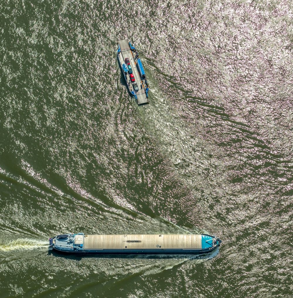Luftbild Orsoy - Fahrt eines Fähr- Schiffes und eines Schüttgutfrachters auf dem Rhein in Orsoy im Bundesland Nordrhein-Westfalen, Deutschland