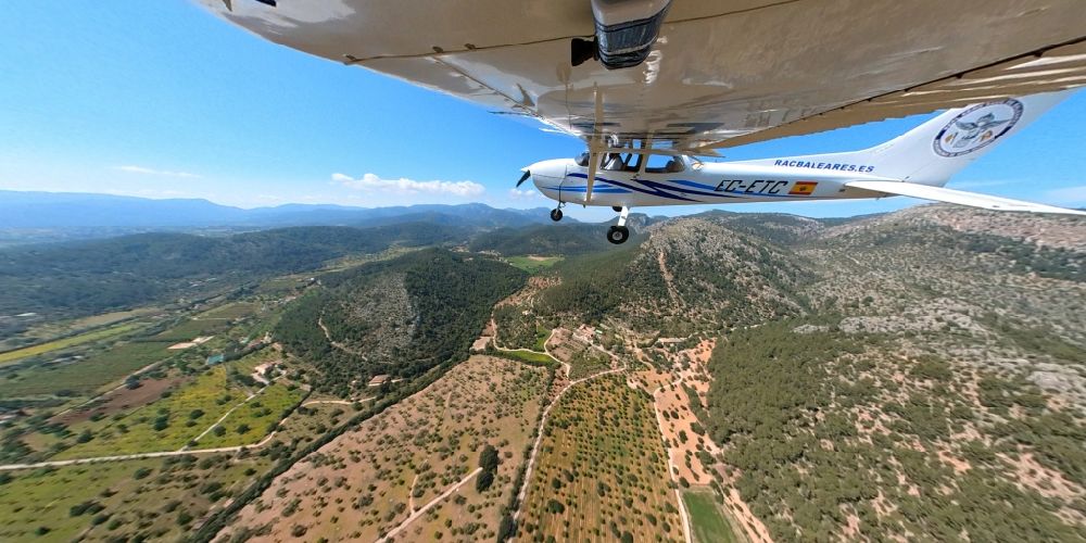 Llubi von oben - Fish Eye- Perspektive Flugzeug Cessna 172 mit der Kennung EC-ETC im Fluge über dem Luftraum in Llubi in Balearische Insel Mallorca, Spanien