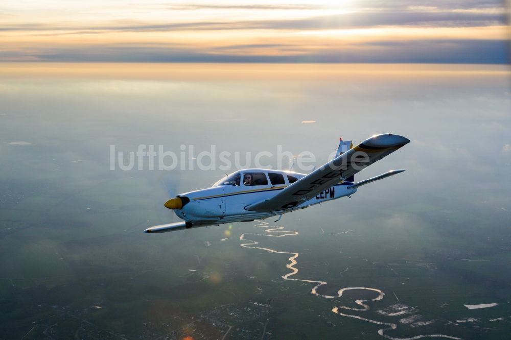Deinste aus der Vogelperspektive: Flugzeug PA-28R-200 Arrow II im Flug über in Deinste im Bundesland Niedersachsen, Deutschland
