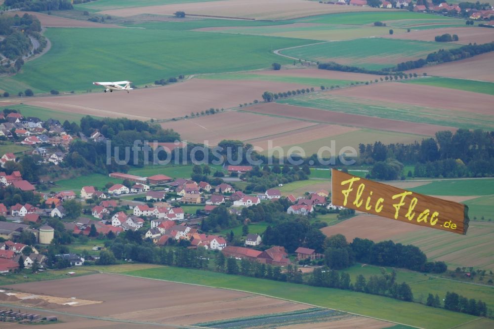 Göttingen aus der Vogelperspektive: Flugzeug Aviat Husky mit Banner des Zirkus Flic Flac im Fluge über dem Luftraum in Göttingen im Bundesland Niedersachsen