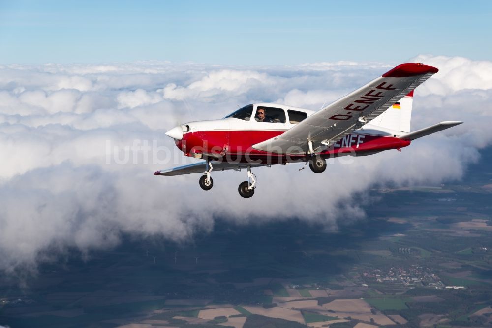 Gnarrenburg aus der Vogelperspektive: Flugzeug Piper Pa28 D-ENFF im Fluge über den Wolken bei Gnarrenburg im Bundesland Niedersachsen, Deutschland