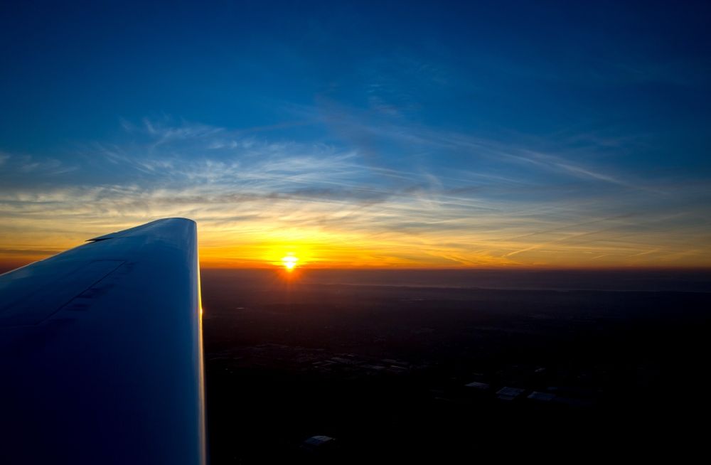 Dortmund aus der Vogelperspektive: Flugzeug- Tragfläche eines Motorseglers am Sonnenuntergangs- Horizont im Fluge über dem Luftraum in Dortmund im Bundesland Nordrhein-Westfalen