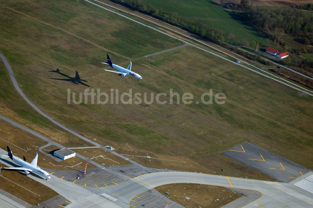 München-Flughafen aus der Vogelperspektive: Frachtflugzeug von FedEx Express beim Landeanflug auf dem Flughafen in München-Flughafen im Bundesland Bayern, Deutschland