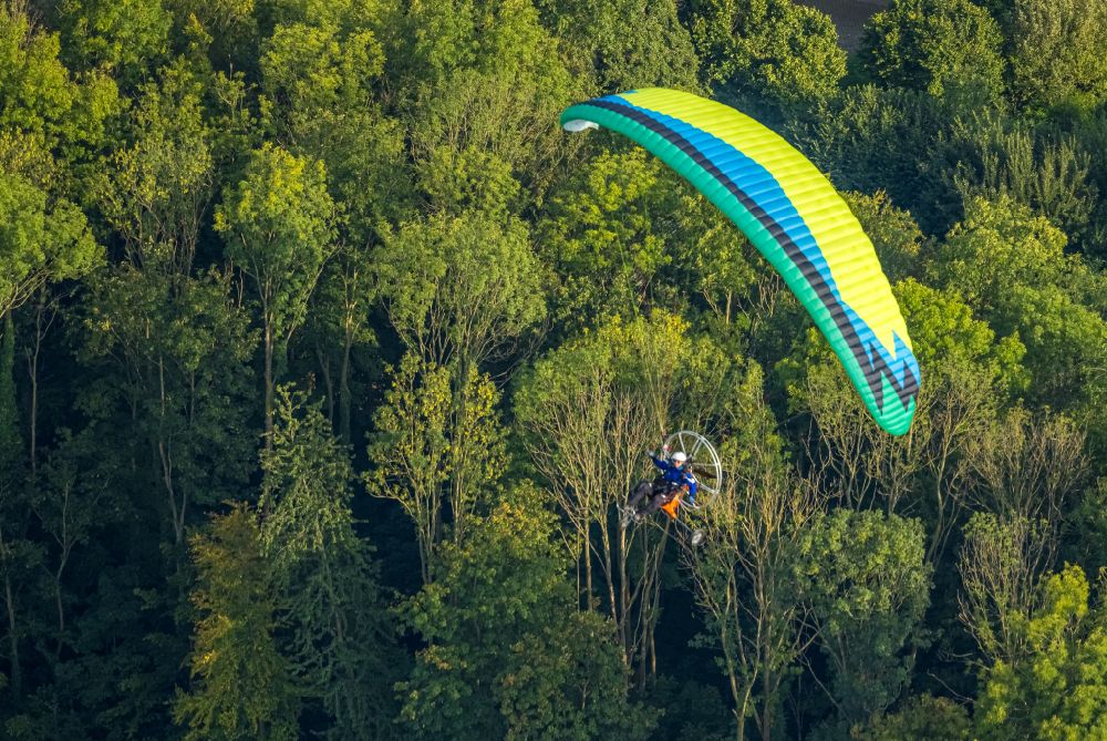 Werl von oben - Motorisierter Gleitschirm im Fluge über dem Luftraum über ein Waldgebiet in Werl im Bundesland Nordrhein-Westfalen, Deutschland