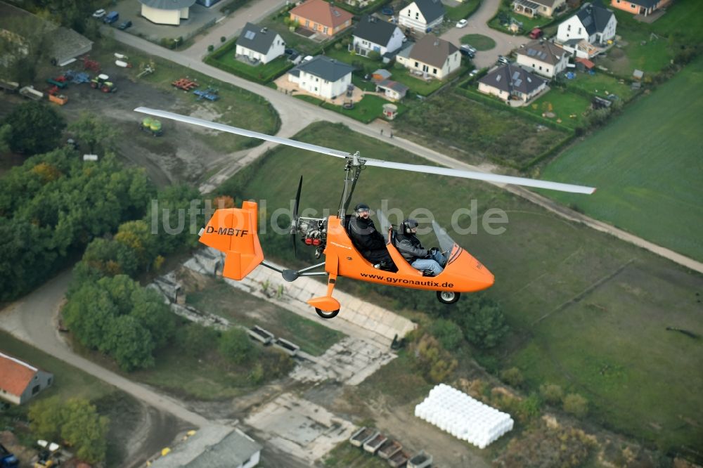Luftbild Saarmund - Orange farbiger Ultraleicht - Gyrokopter der Flugschule Gyronautix mit der Kennung D-MBTF im Fluge über dem Luftraum in Saarmund im Bundesland Brandenburg