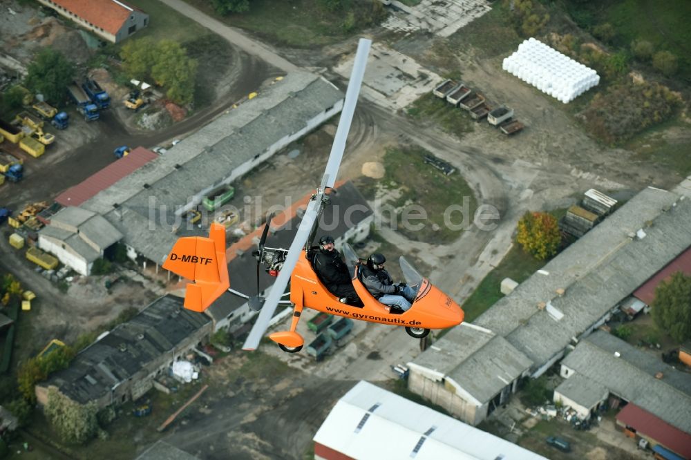 Saarmund von oben - Orange farbiger Ultraleicht - Gyrokopter der Flugschule Gyronautix mit der Kennung D-MBTF im Fluge über dem Luftraum in Saarmund im Bundesland Brandenburg