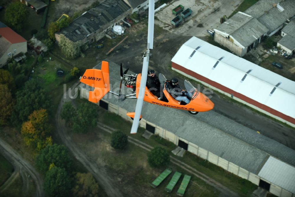 Luftbild Saarmund - Orange farbiger Ultraleicht - Gyrokopter der Flugschule Gyronautix mit der Kennung D-MBTF im Fluge über dem Luftraum in Saarmund im Bundesland Brandenburg