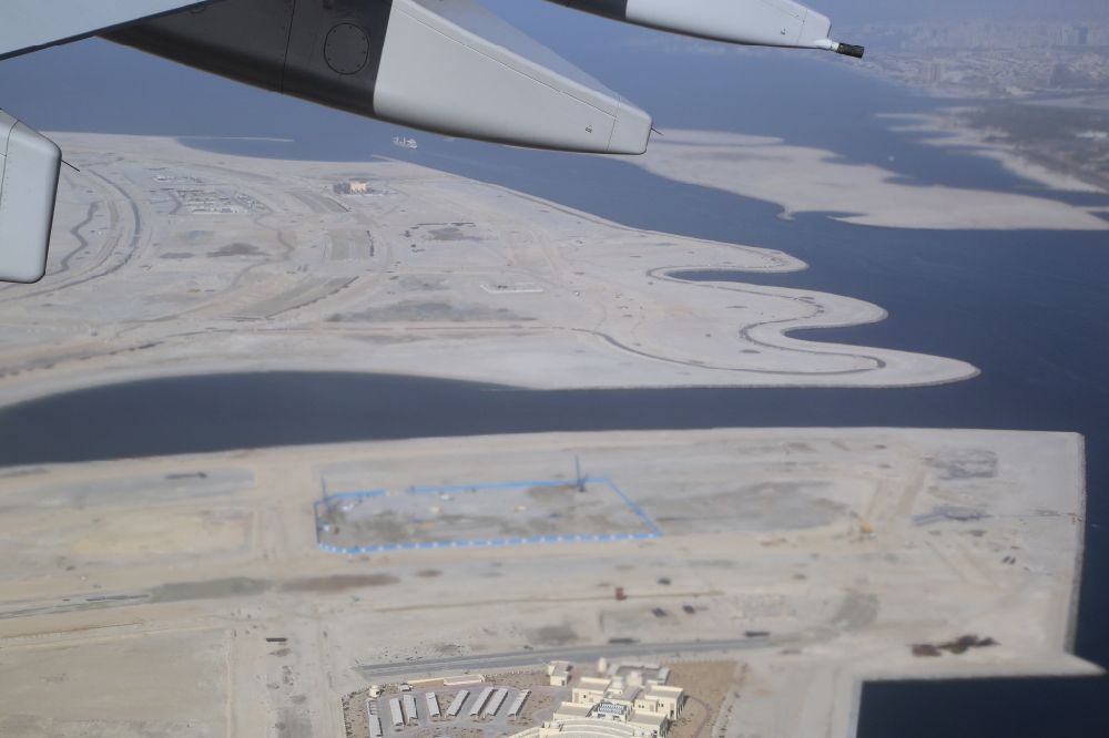 Dubai von oben - Passagierflugzeug Airbus A380 beim Start und Steigflug nach Westen über die Deira Islands vom Flughafen in Dubai in Vereinigte Arabische Emirate