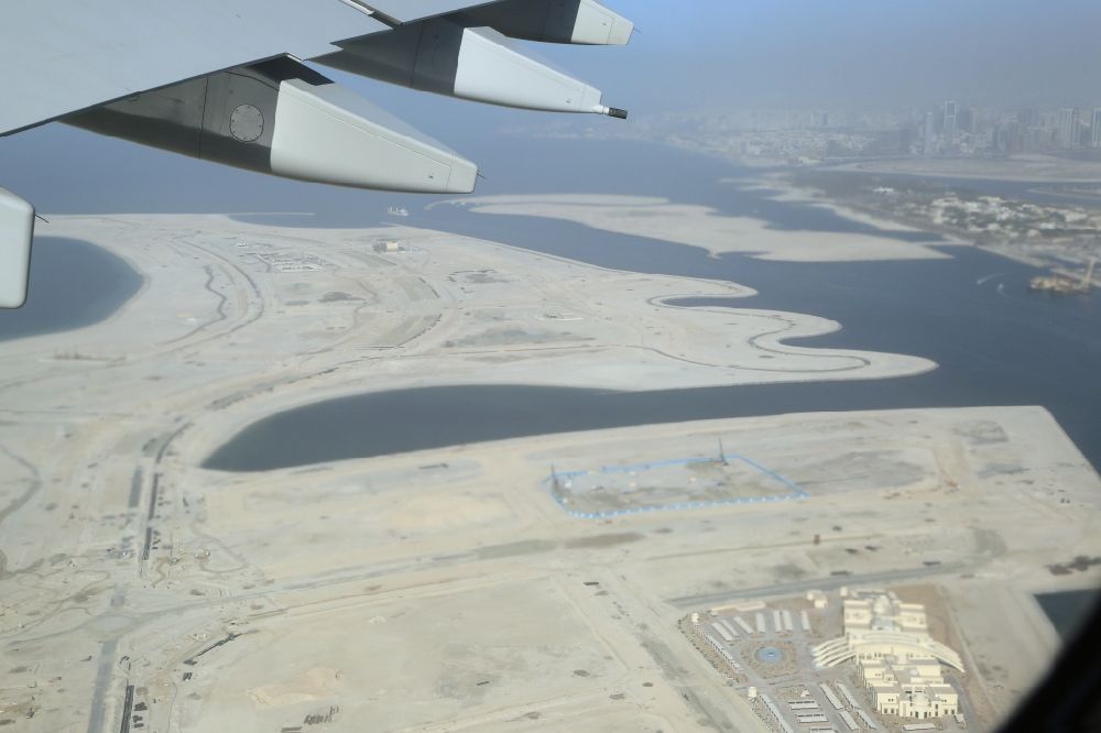 Dubai aus der Vogelperspektive: Passagierflugzeug Airbus A380 beim Start und Steigflug nach Westen über die Deira Islands vom Flughafen in Dubai in Vereinigte Arabische Emirate