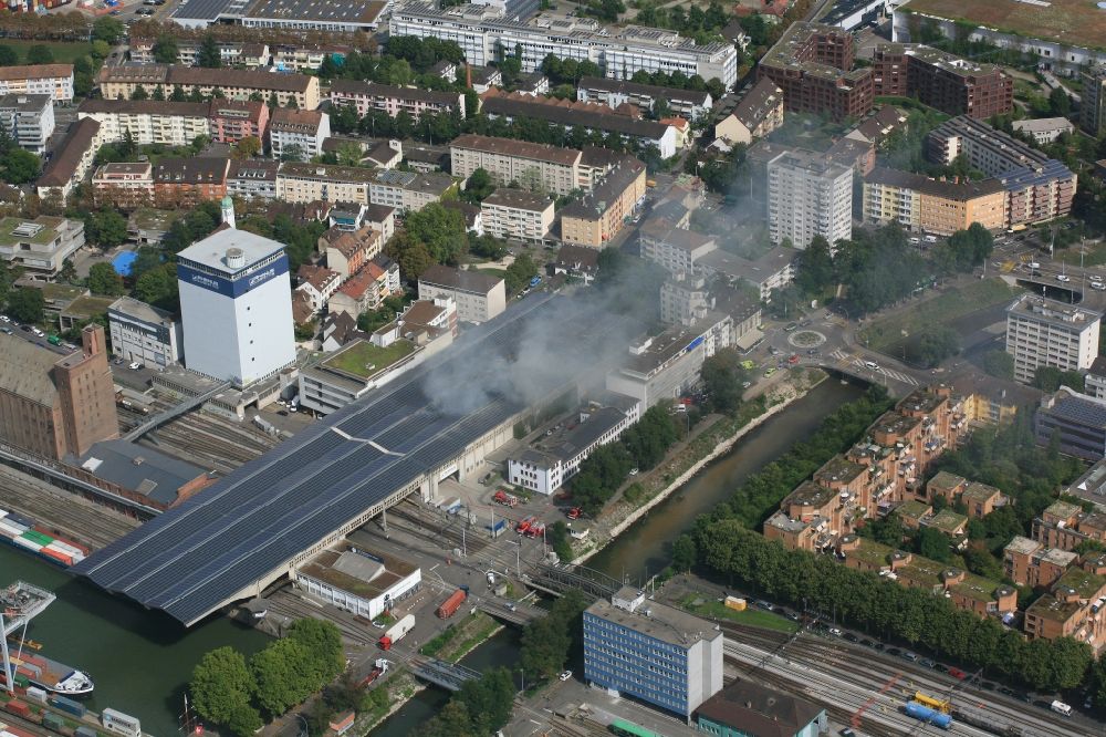 Basel von oben - Rauch- und Flammenbildung während der Löscharbeiten zum Brand in der Lagerhalle von Rhenus in Basel, Schweiz