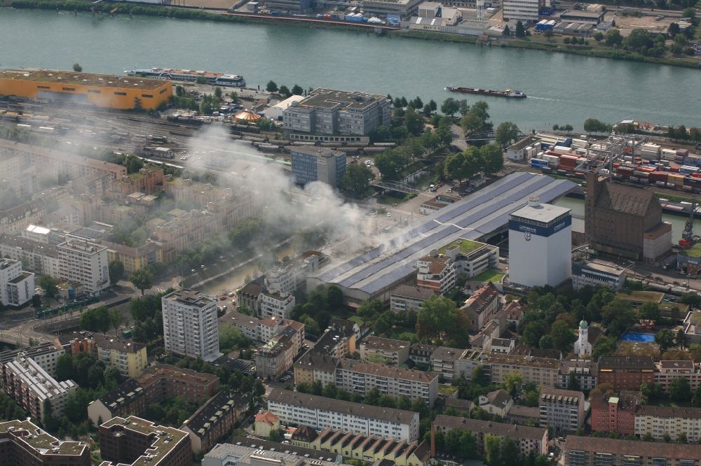 Luftbild Basel - Rauch- und Flammenbildung während der Löscharbeiten zum Brand in der Lagerhalle von Rhenus in Basel, Schweiz