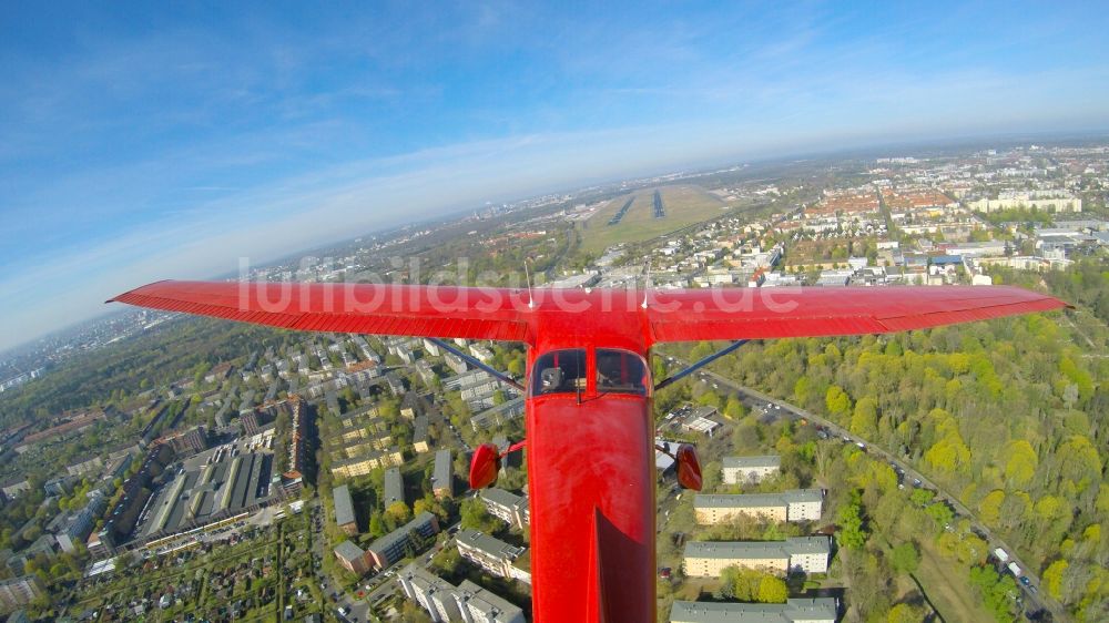 Berlin aus der Vogelperspektive: Rote Cessna beim Tiefanflug über die Piste 26R am Flughafen Tegel in Berlin, Deutschland