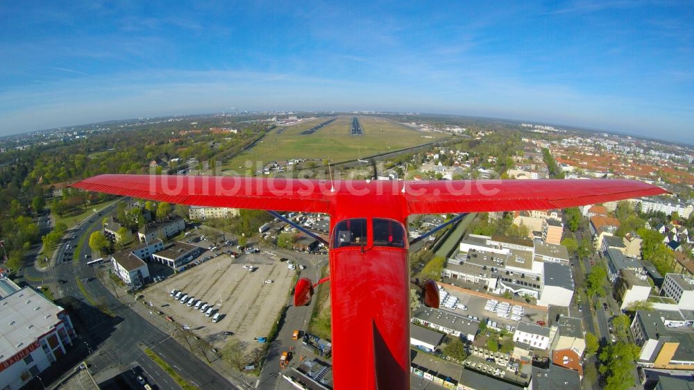Luftaufnahme Berlin - Rote Cessna beim Tiefanflug über die Piste 26R am Flughafen Tegel in Berlin, Deutschland