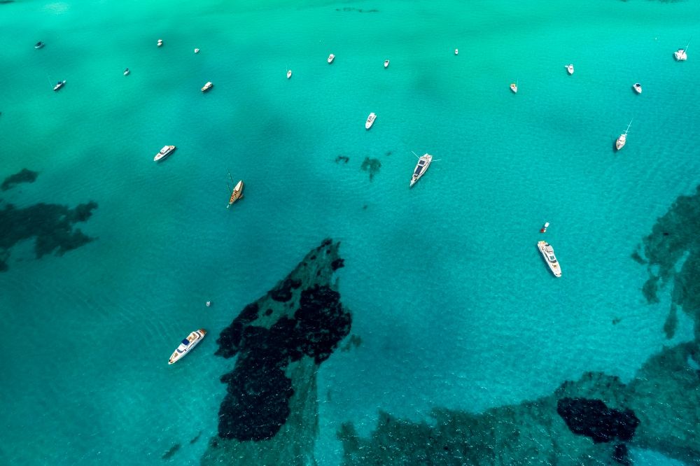 Ses Covetes von oben - Schiffe und Wasseroberfläche an der Meeres- Küste Cala Magrana in Ses Covetes in Islas Baleares, Spanien