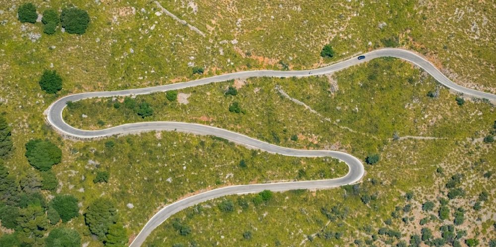 Escorca von oben - Serpentinenförmiger Kurvenverlauf einer Straßenführung in Escorca in Balearische Insel Mallorca, Spanien