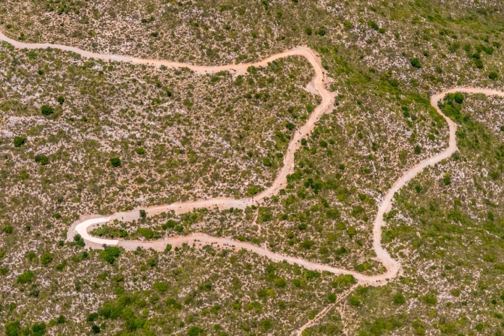 Cala Mesquida von oben - Serpentinenförmiger Kurvenverlauf einer Wegführung in Cala Mesquida in Balearische Inseln, Spanien