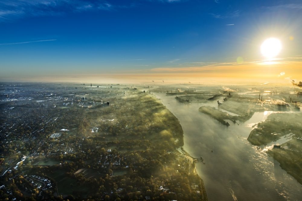 Hamburg von oben - Sonnen- Untergang über der Landschaft des mit Hochnebel bedeckten Hafenanlagen in Hamburg, Deutschland
