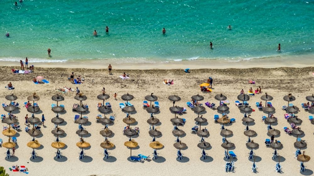 Palmanova aus der Vogelperspektive: Sonnenschirmreihen am Sand- Strand im Küstenbereich des Palmanova Beach - Platja de na Nadala in Palmanova in Balearische Insel Mallorca, Spanien